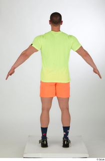 Joel a-pose dressed green sneakers orange shorts sports standing whole…